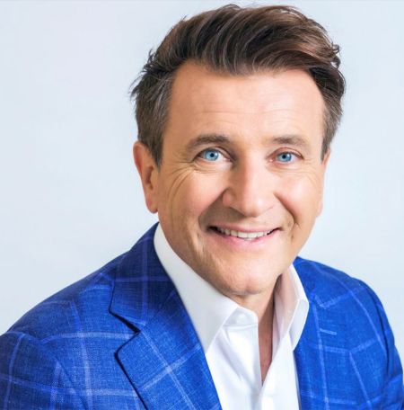 He is wearing a blue coat with white shirt.